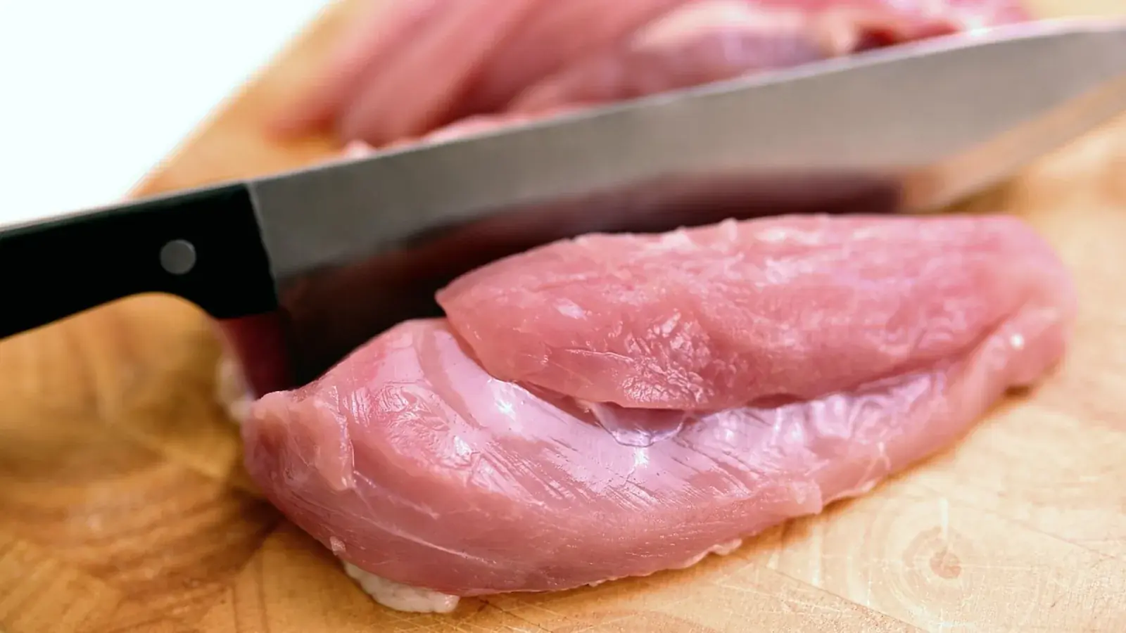 Rohes Geflügelfleisch mit einem Messer